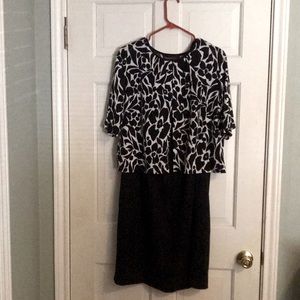 Connected woman black lined sleeveless dress with black and white sweater.